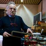 Mentre si serve di un seghetto d�antan per tagliare e modellare i tubi necessari al funzionamento della cucina